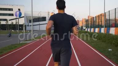 运动员在跑道上跑步，在日出时跑步。
